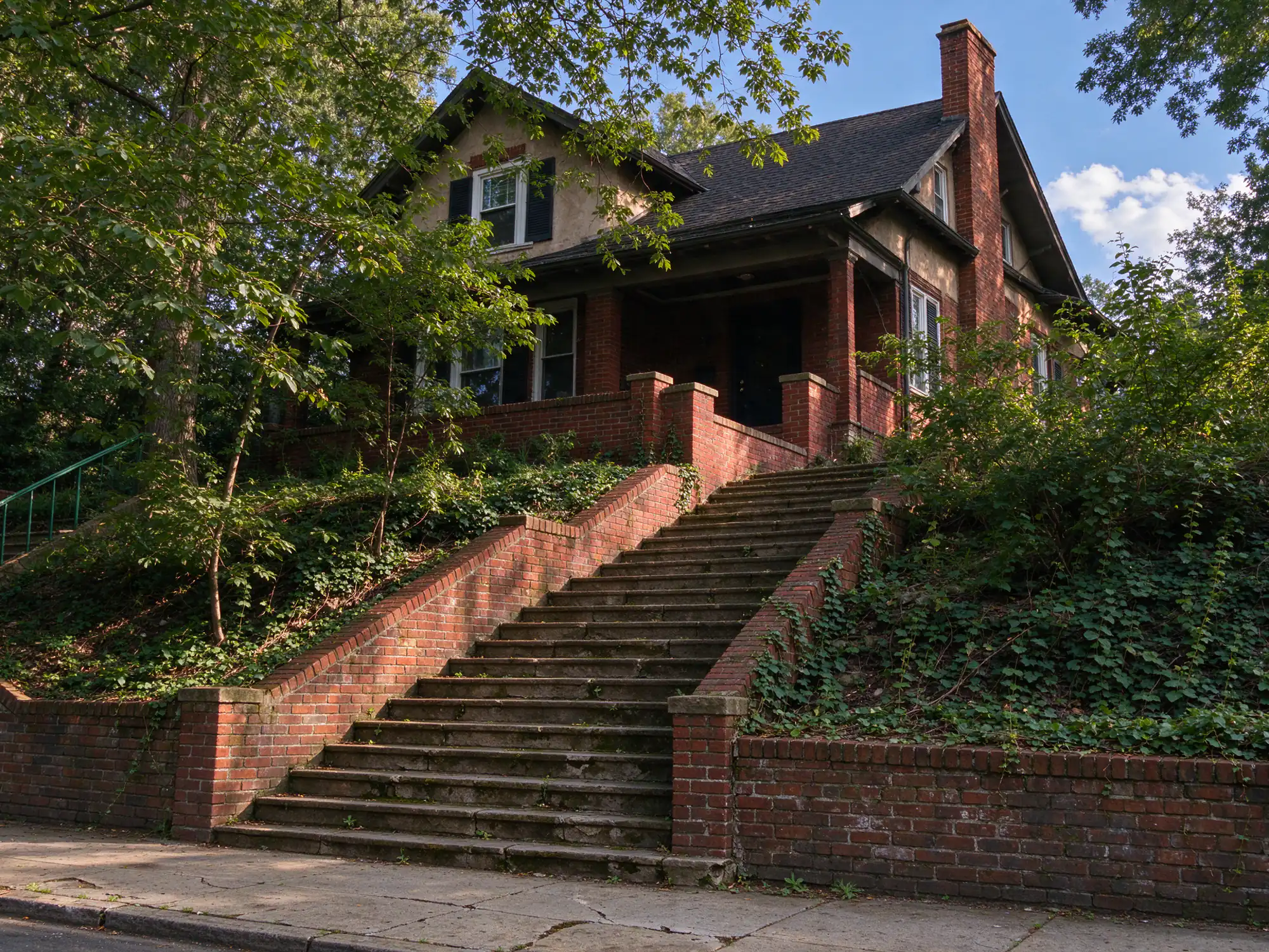 Long run of stone entry steps between brick cheek walls climbing a steep lot to a prewar house in West Orange, NJ
